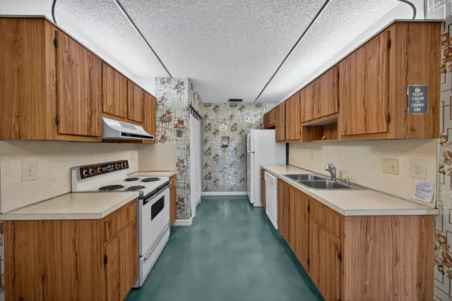 a kitchen with stainless steel appliances granite countertop a stove a sink dishwasher and cabinets with wooden floor
