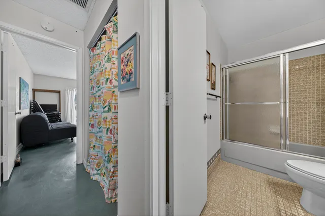 a living room with furniture and a glass door shower
