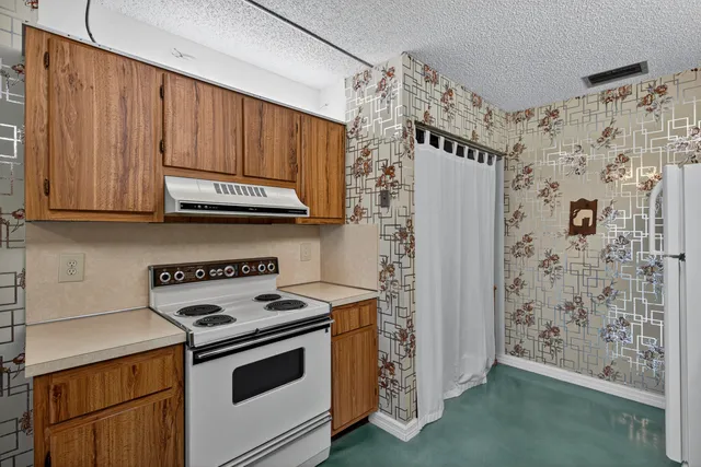 a kitchen with stainless steel appliances wooden cabinets and a stove top oven