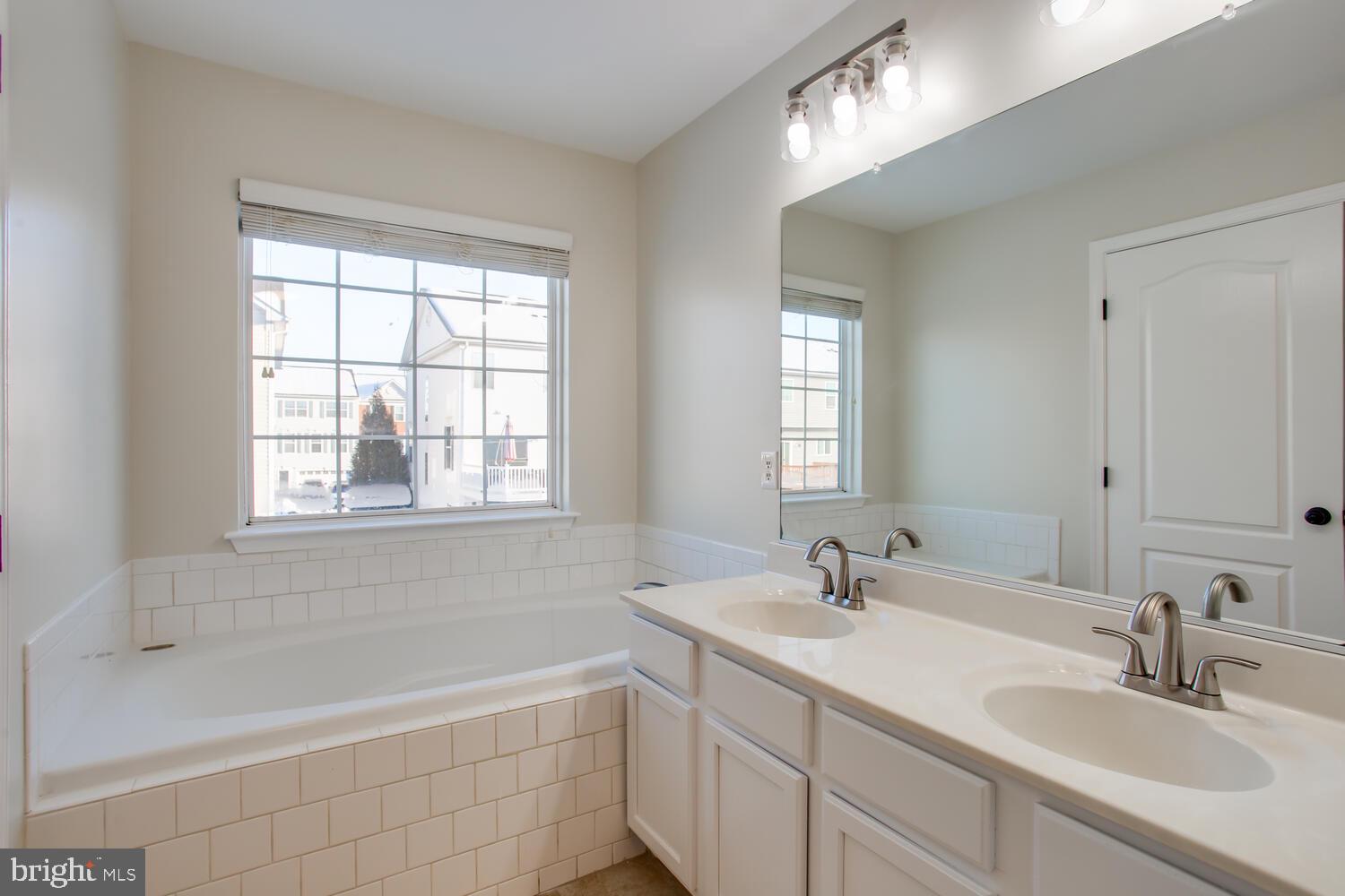 7024 Commander Howe Terrace Brandywine, MD 20613 - Photo 22 of 34 a bathroom with double vanity sinks and a bathtub