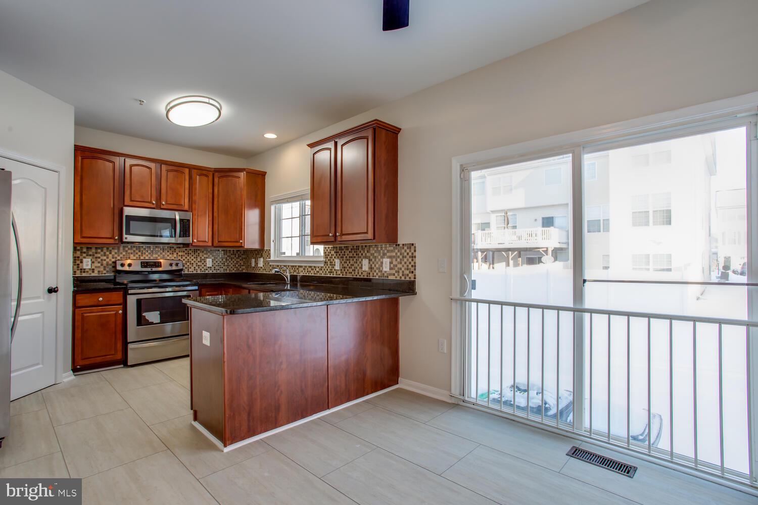 7024 Commander Howe Terrace Brandywine, MD 20613 - Photo 8 of 34 a kitchen with stainless steel appliances granite countertop a stove a sink and a refrigerator
