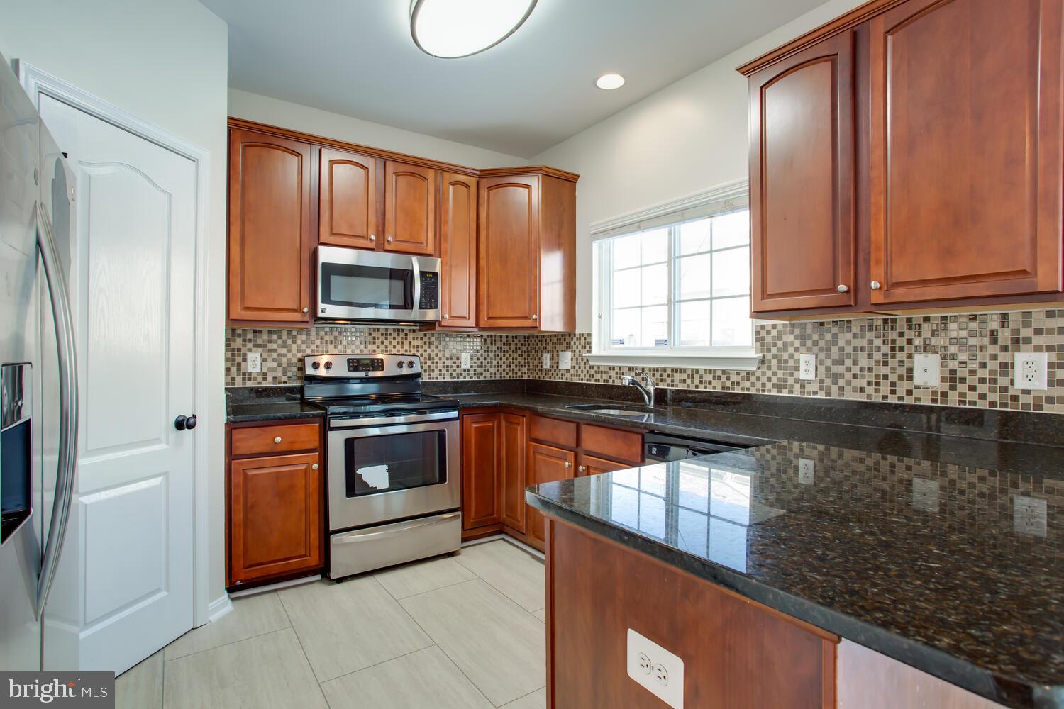 7024 Commander Howe Terrace Brandywine, MD 20613 - Photo 10 of 34 a kitchen with stainless steel appliances granite countertop a stove a sink dishwasher a refrigerator and a microwave oven