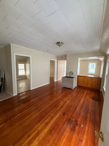 a hallway view with wooden floor and staircase