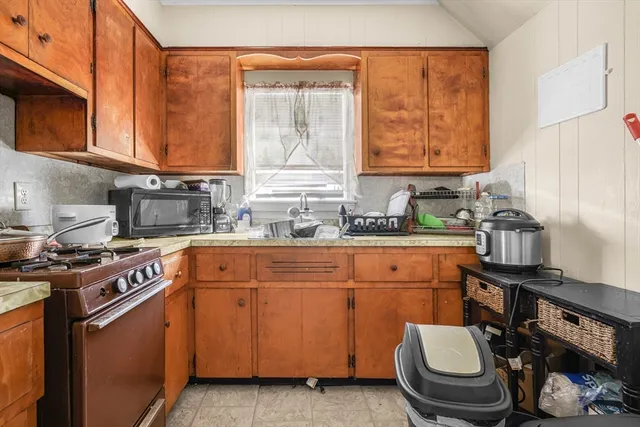 a kitchen with stainless steel appliances a sink a stove cabinets and a window