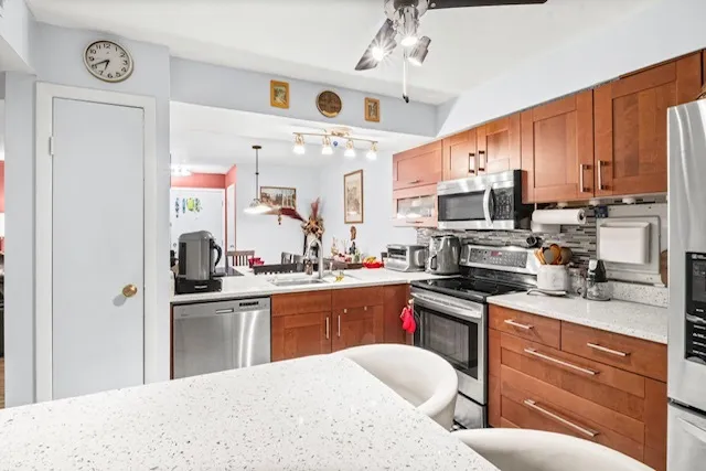 a kitchen with stainless steel appliances granite countertop a sink dishwasher stove refrigerator and cabinets with wooden floor