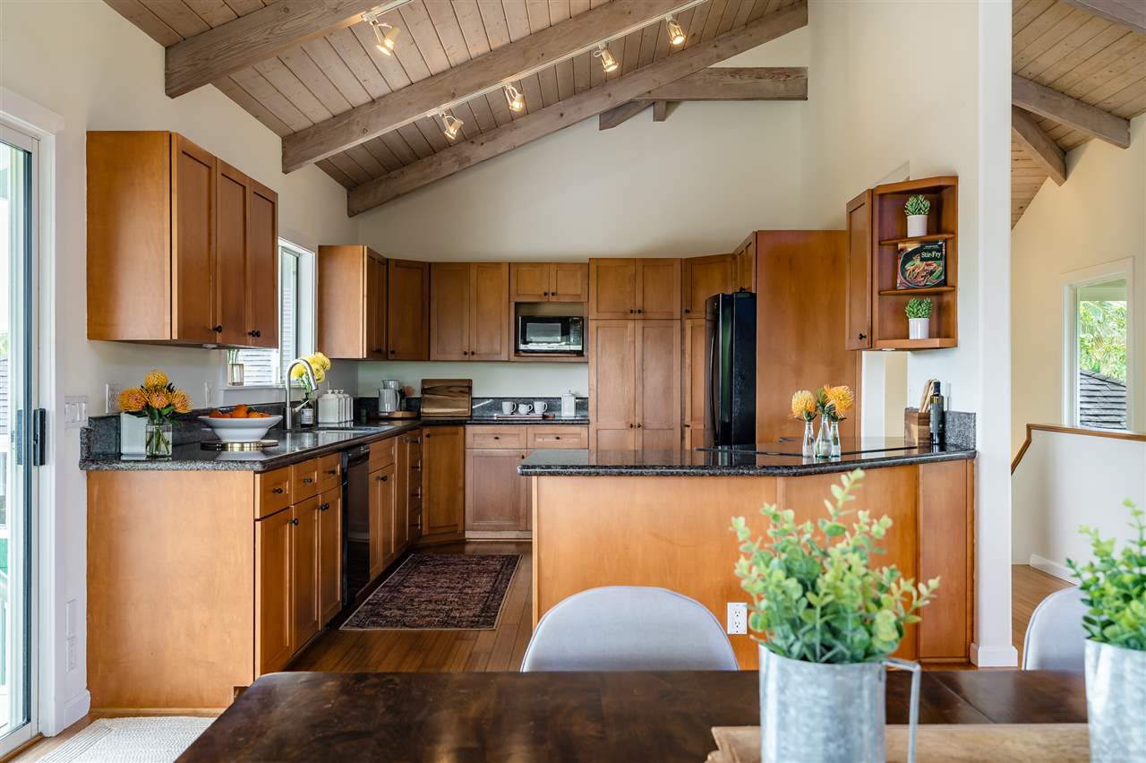 3175 Ua Noe Place, Unit A Haiku, HI 96708 - Photo 9 of 29 a kitchen with stainless steel appliances granite countertop a refrigerator a stove and a wooden cabinets