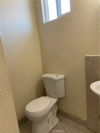 a white toilet sitting next to a white wall