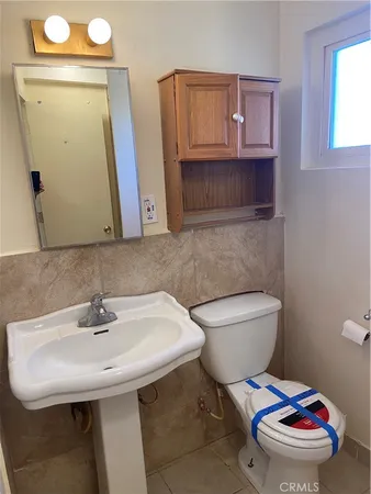 a bathroom with a sink a toilet and mirror