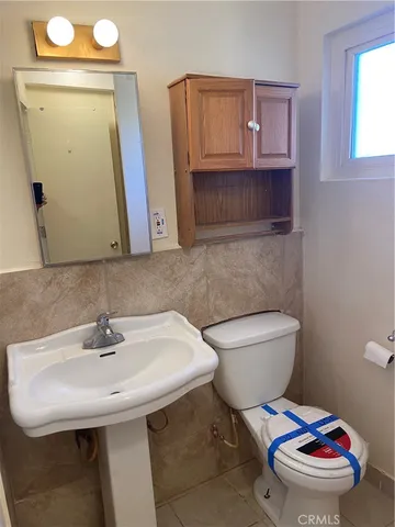 a bathroom with a sink a toilet and mirror