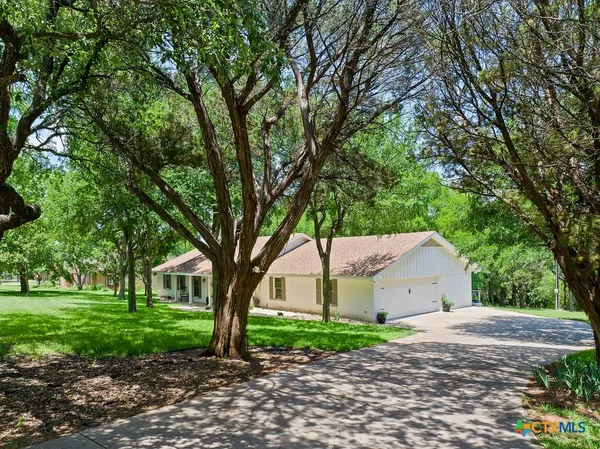 a front view of a house with a yard and tree