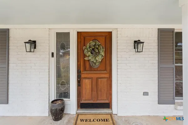 wooden floor with a fireplace and a chandelier