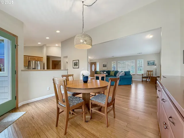 a view of a dining room and livingroom with furniture wooden floor a chandelier