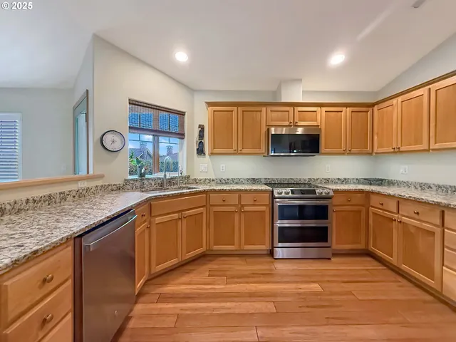 a kitchen with stainless steel appliances granite countertop a stove sink and cabinets