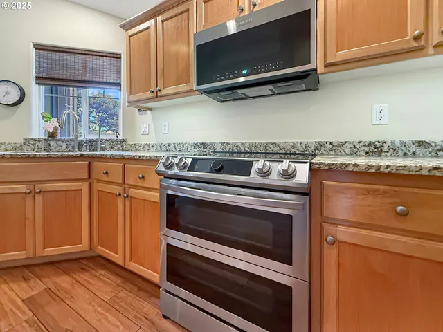 a kitchen with granite countertop a stove and a microwave