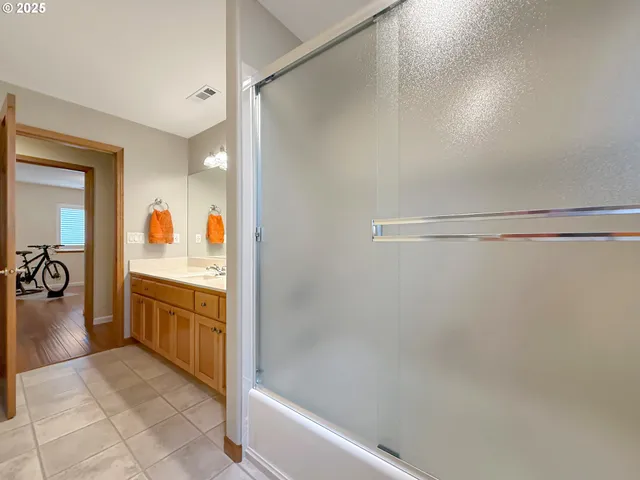 a bathroom with a granite countertop sink a vanity and shower