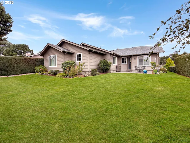 a backyard of a house with large trees and plants