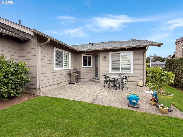 a backyard of a house with table and chairs