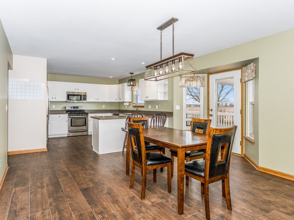 265 Rollin Road Somonauk, IL 60552 - Photo 12 of 33 a dining room with stainless steel appliances a table and chairs with wooden floor