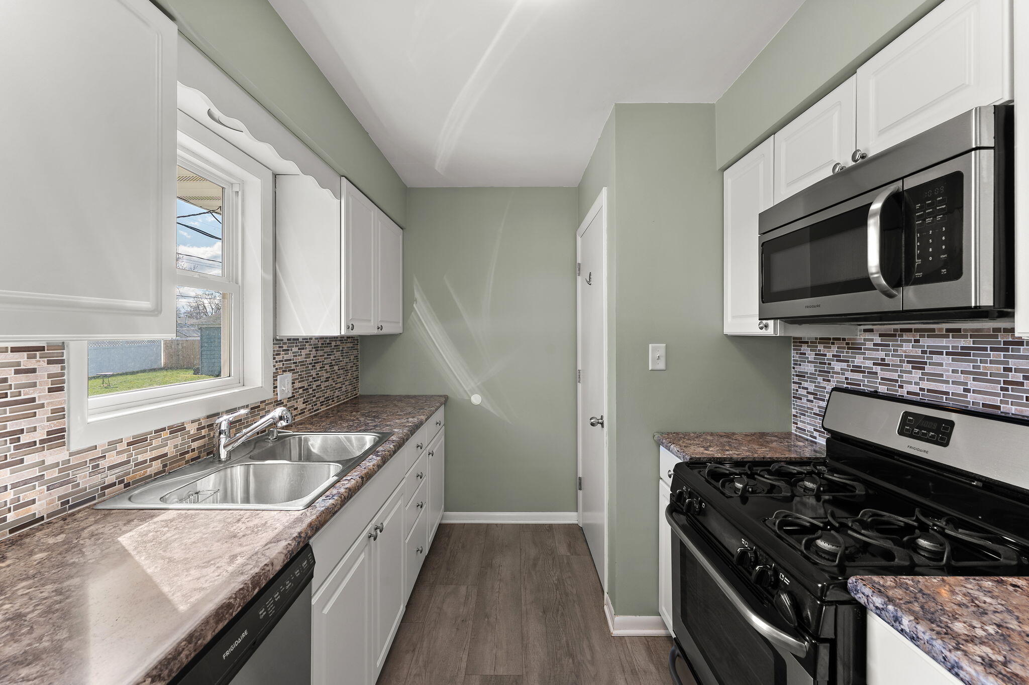 947 North Wood Street Griffith, IN 46319 - Photo 12 of 25 a kitchen with stainless steel appliances granite countertop a stove a sink and a microwave