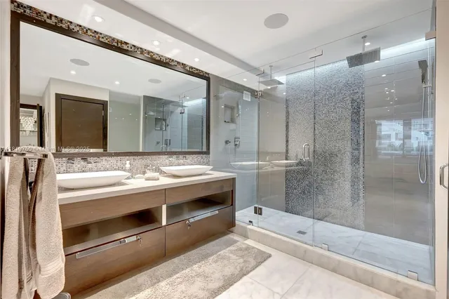 a spacious bathroom with a shower sink and mirror