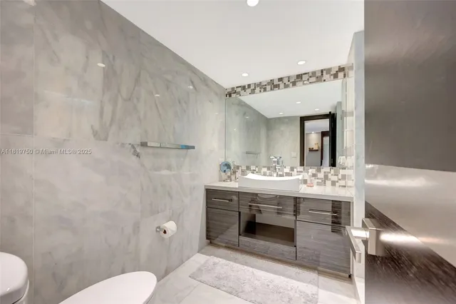 a spacious bathroom with a toilet a sink and mirror