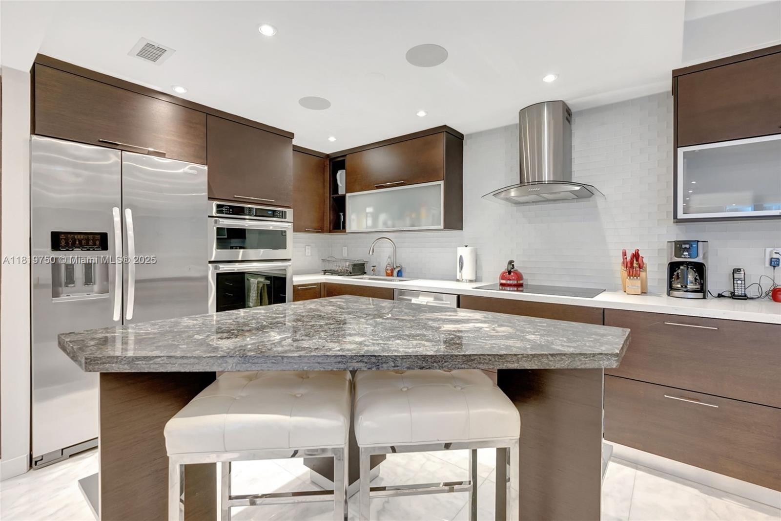 2301 Collins Avenue, Unit 307 Miami Beach, FL 33139 - Photo 8 of 17 a kitchen with stainless steel appliances granite countertop a sink a stove and a refrigerator