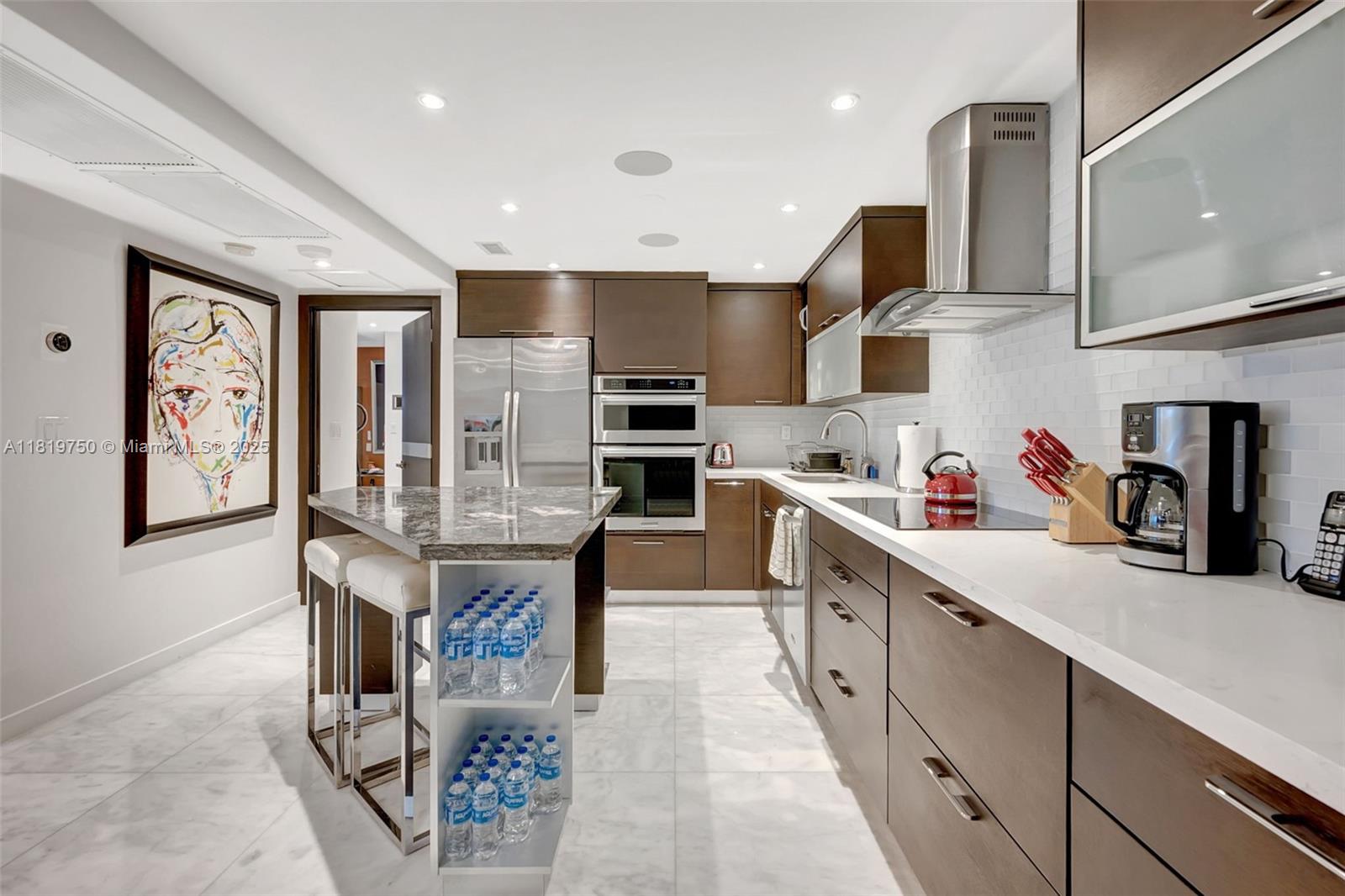 2301 Collins Avenue, Unit 307 Miami Beach, FL 33139 - Photo 10 of 17 a kitchen with stainless steel appliances granite countertop a refrigerator a sink dishwasher a dining table and chairs with wooden floor