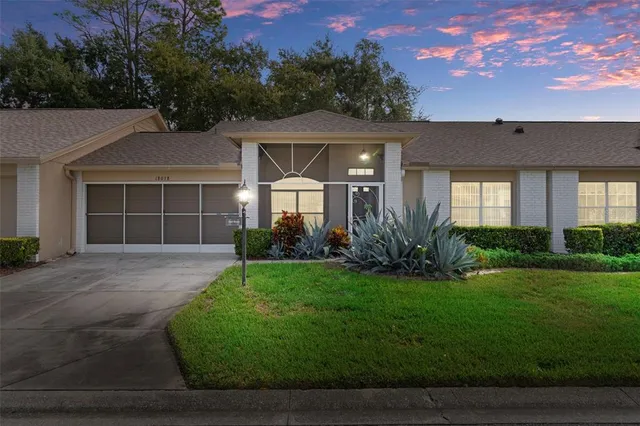 a front view of a house with a garden and yard