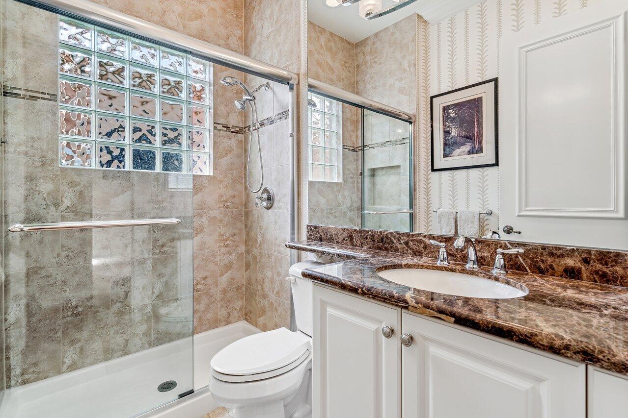 9047 Ribbons Ridge Point Boynton Beach, FL 33473 - Photo 12 of 37 a bathroom with a granite countertop sink a toilet a mirror a vanity and shower