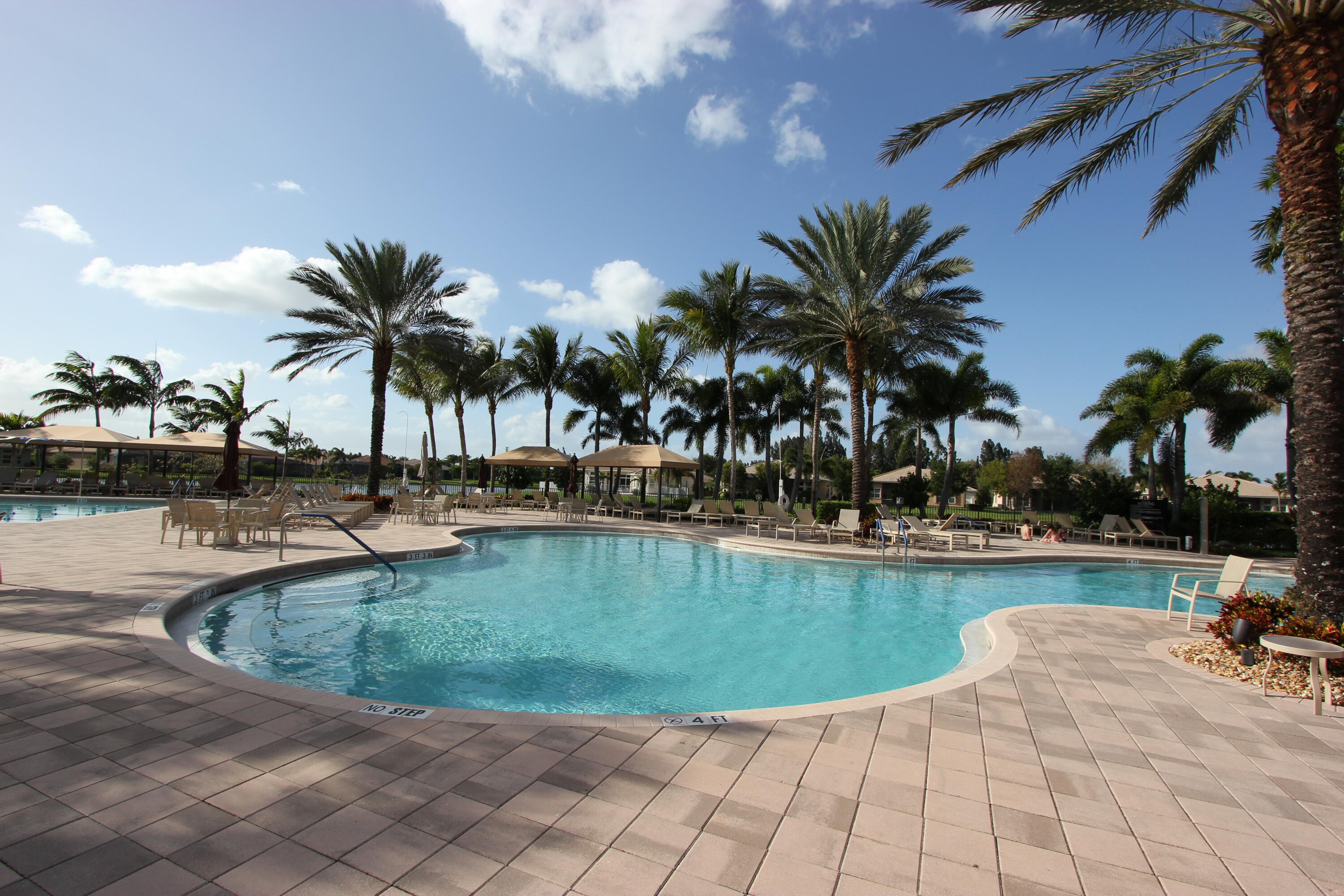 9047 Ribbons Ridge Point Boynton Beach, FL 33473 - Photo 36 of 37 a view of a swimming pool with a chair and palm trees