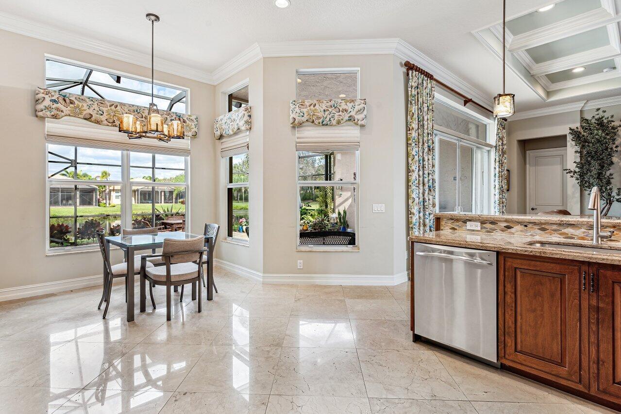 9047 Ribbons Ridge Point Boynton Beach, FL 33473 - Photo 8 of 37 a dining room with furniture a chandelier and kitchen view