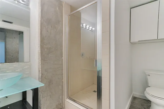 a bathroom with a toilet and a shower