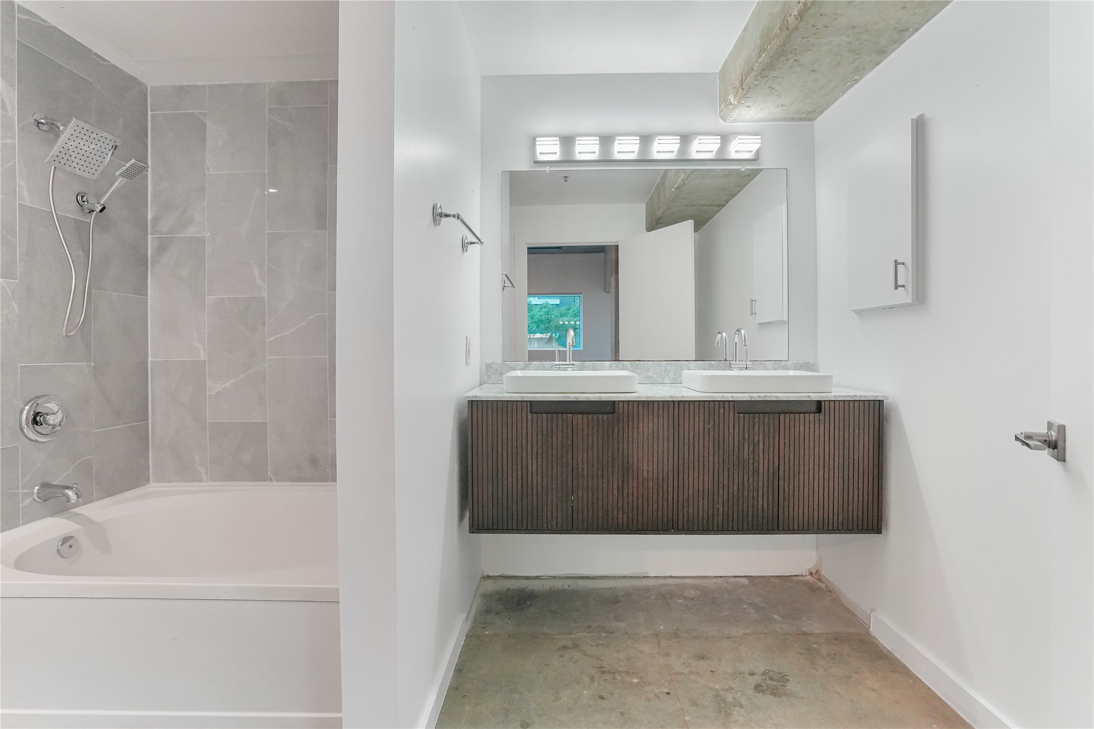 2000 Bagby Street, Unit 2401 Houston, TX 77002 - Photo 10 of 38 a bathroom with a bathtub a mirror a vanity and a shower