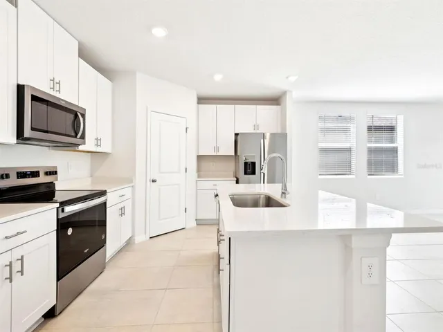 a kitchen with stainless steel appliances granite countertop a refrigerator and a stove top oven