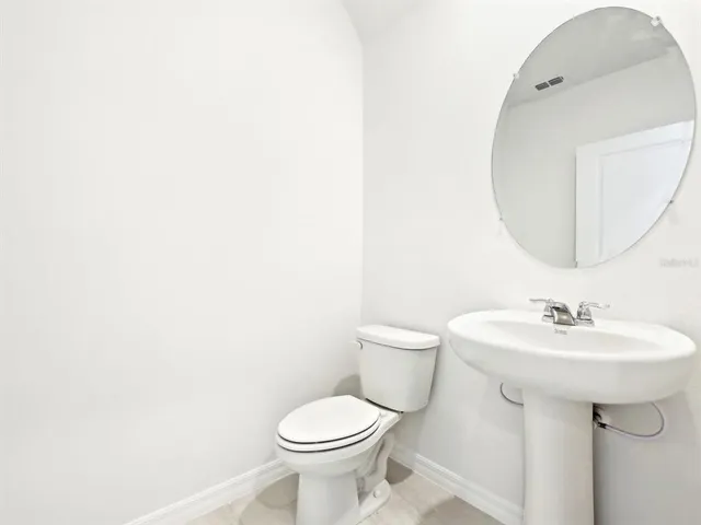 a bathroom with a sink toilet and mirror