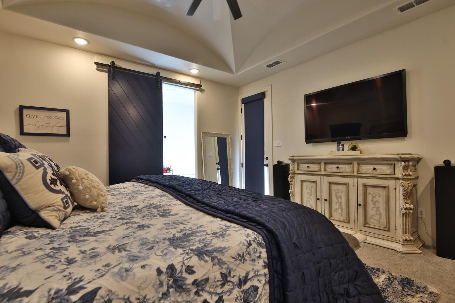 4611 139th Street Lubbock, TX 79424 - Photo 12 of 38 a bedroom with a bed and a flat screen tv