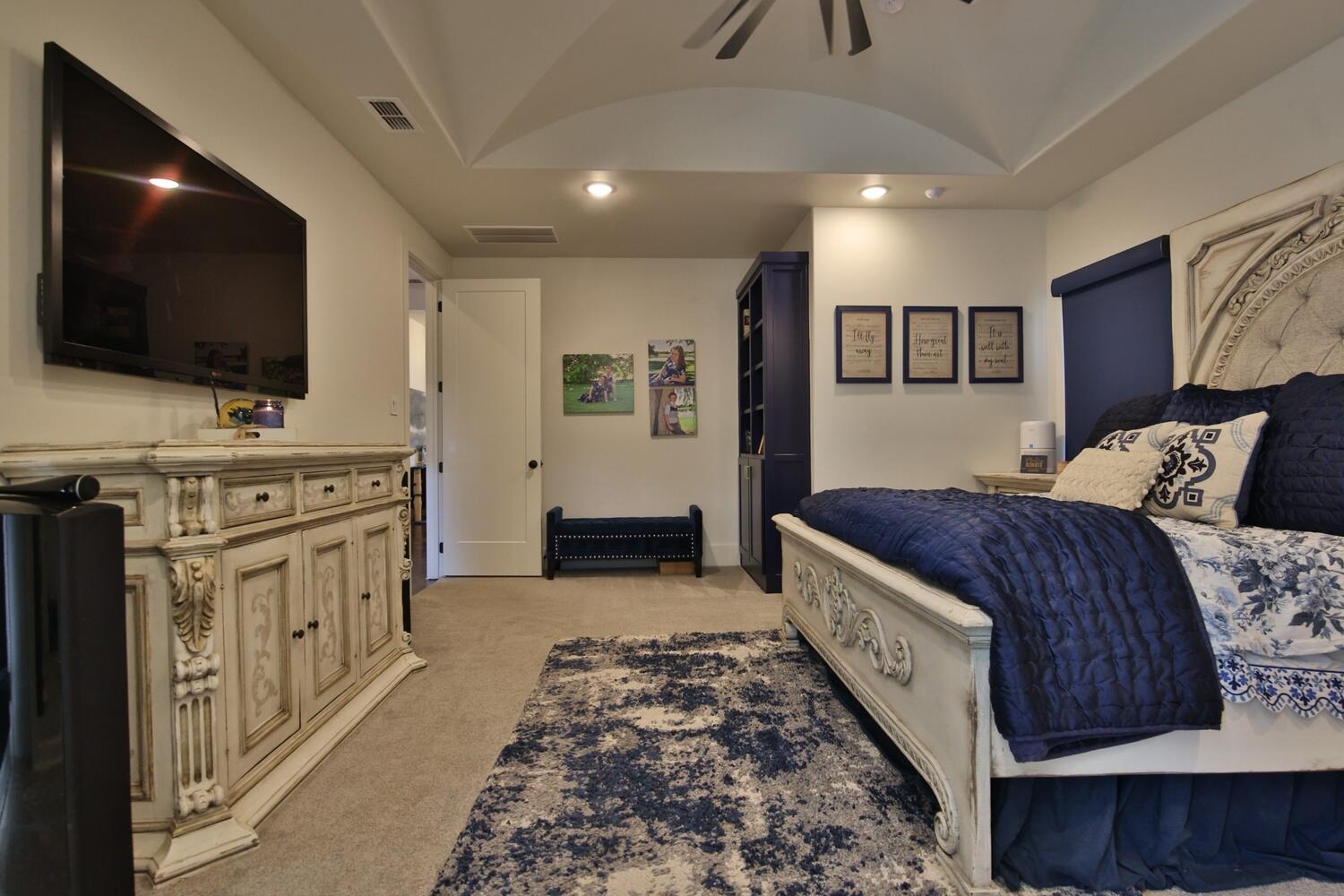 4611 139th Street Lubbock, TX 79424 - Photo 14 of 38 a spacious bedroom with a bed and a flat screen tv