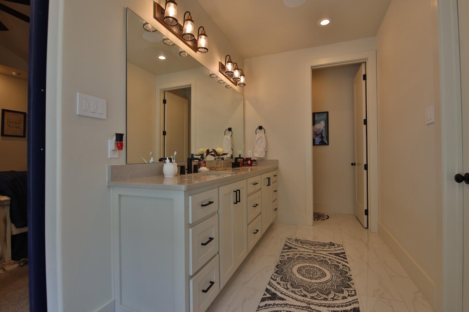 4611 139th Street Lubbock, TX 79424 - Photo 17 of 38 a bathroom with a double vanity sink mirror and shower