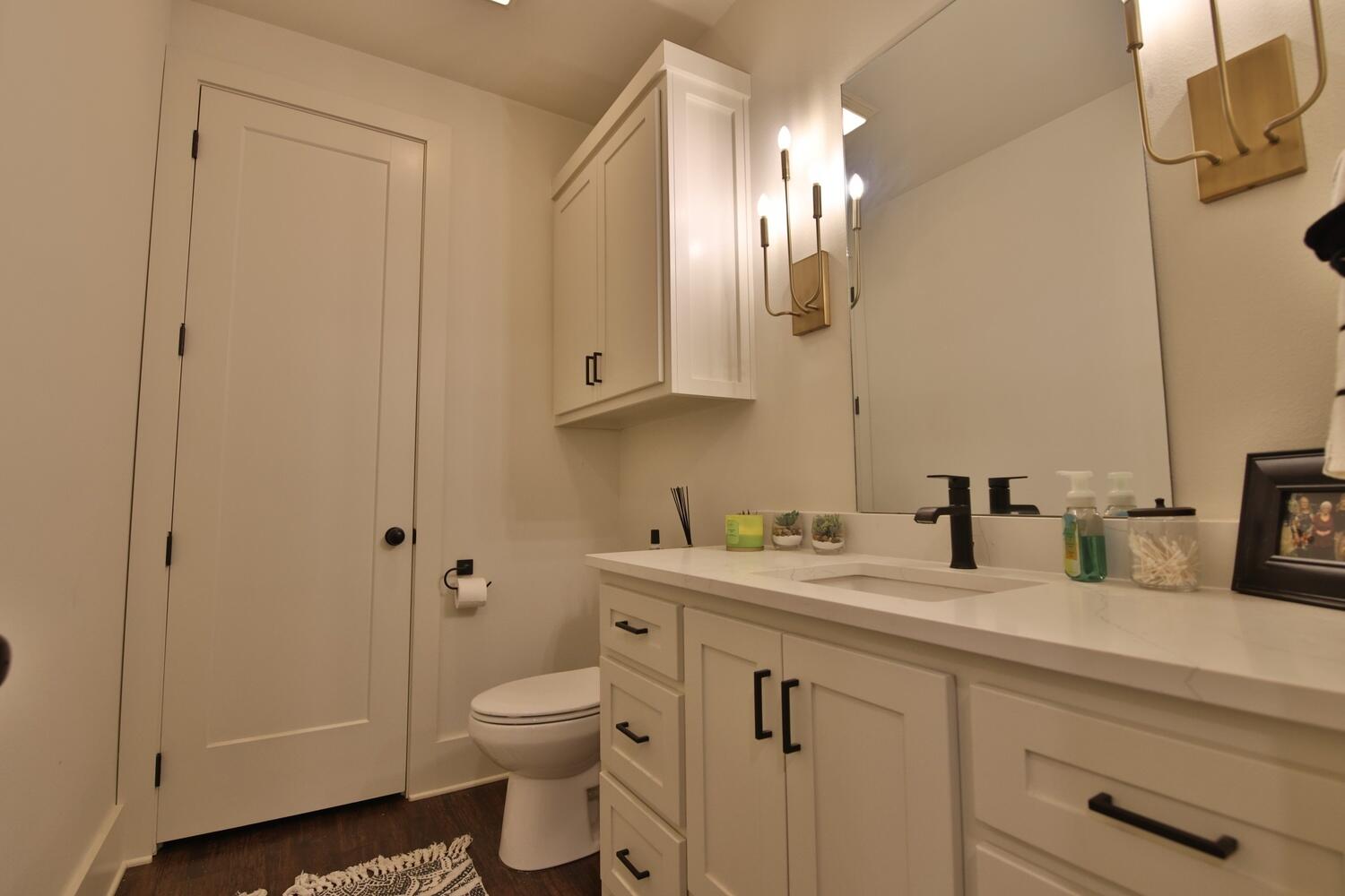 4611 139th Street Lubbock, TX 79424 - Photo 23 of 38 a bathroom with a granite countertop sink a toilet and a mirror