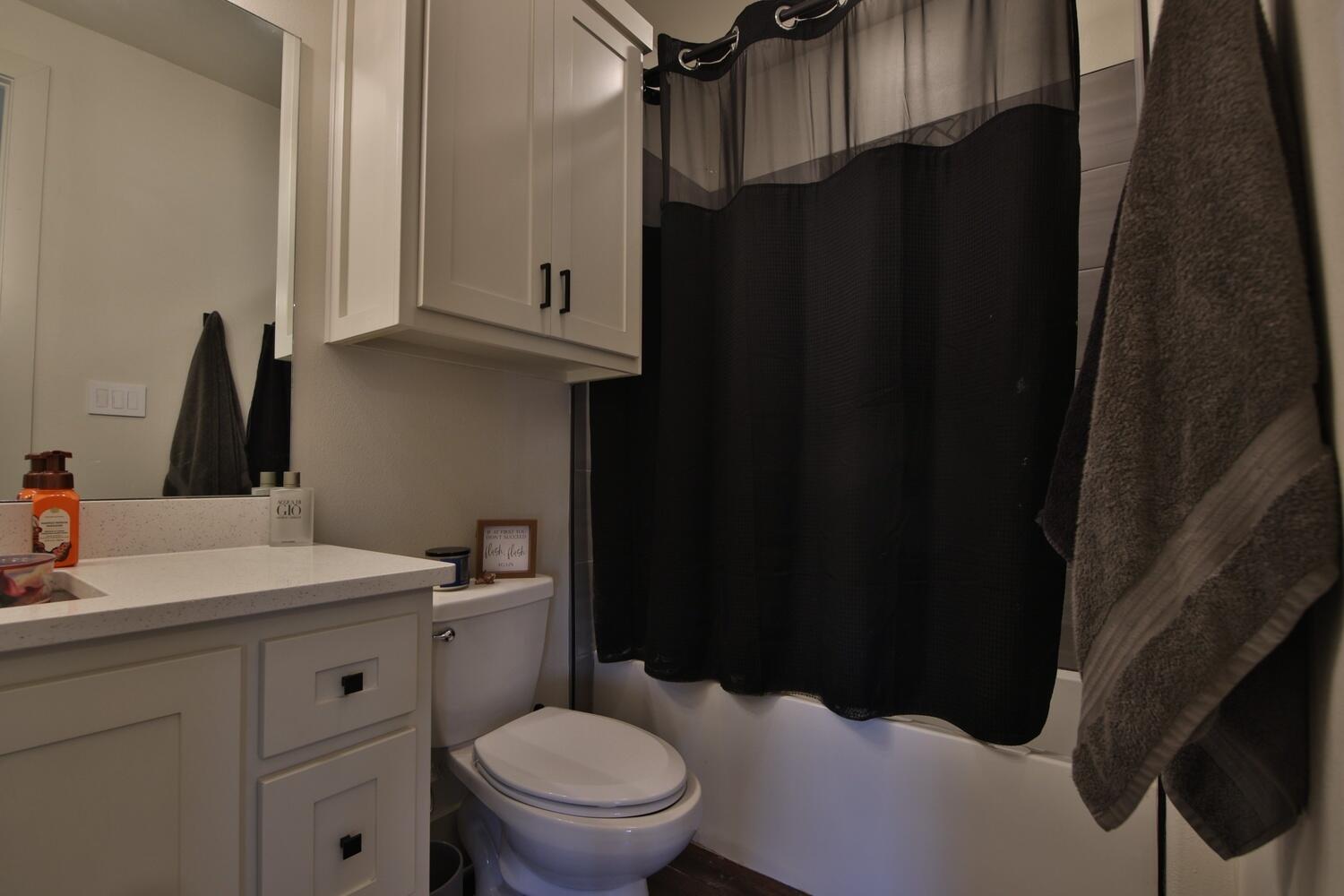 4611 139th Street Lubbock, TX 79424 - Photo 31 of 38 a bathroom with a sink a toilet and a mirror