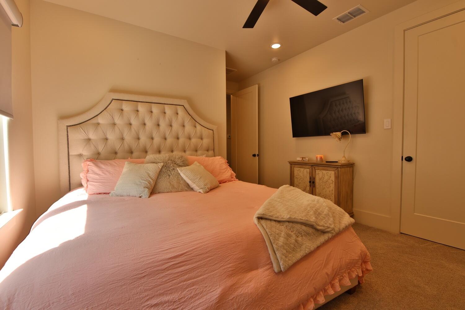 4611 139th Street Lubbock, TX 79424 - Photo 35 of 38 a bedroom with a bed and a flat screen tv