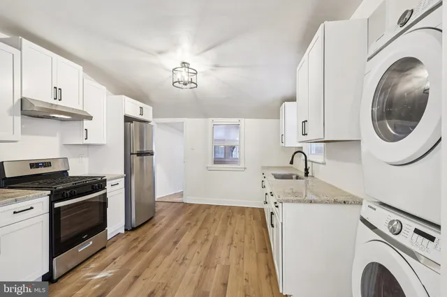 a kitchen with stainless steel appliances granite countertop a sink a stove and refrigerator