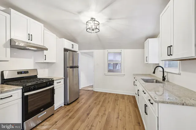 a kitchen with granite countertop a sink stainless steel appliances and cabinets