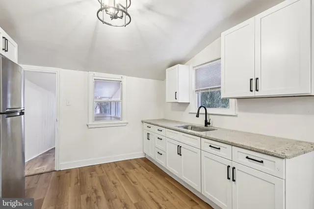 a kitchen with stainless steel appliances granite countertop a sink and a white cabinets
