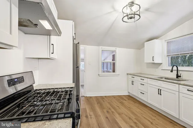 a kitchen with a sink dishwasher a stove and a refrigerator with wooden floor