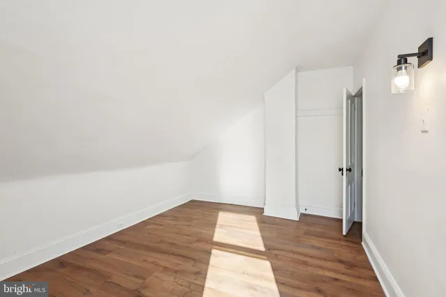 a view of a room with wooden floor and white walls