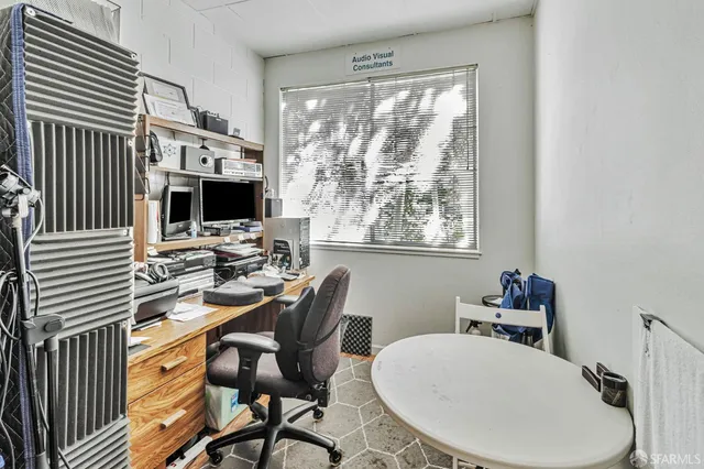 a view of a workspace with furniture and a window