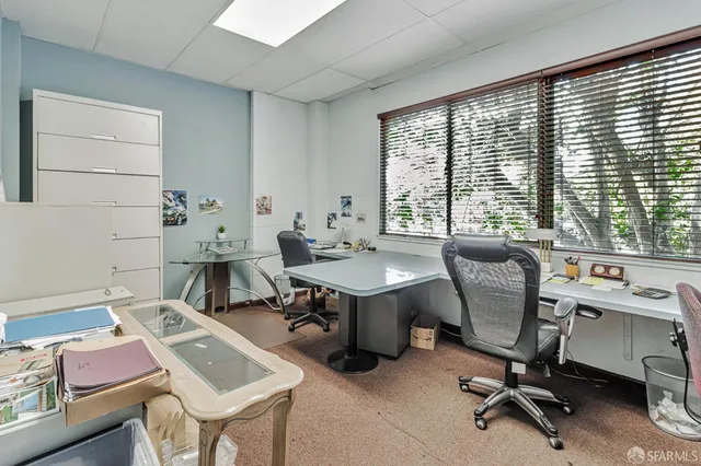a view of a workspace with furniture and a window