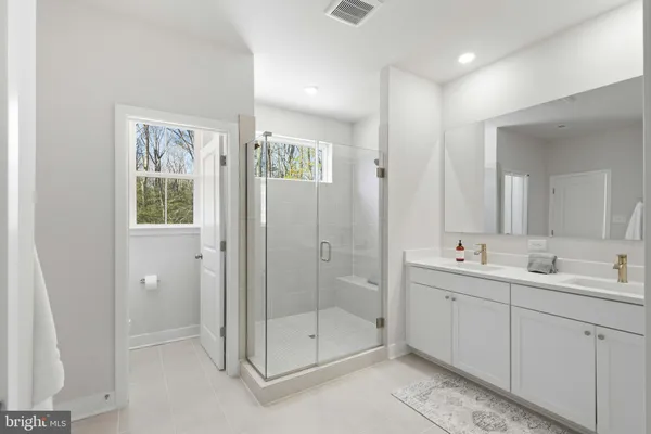 a bathroom with a double vanity sink and shower