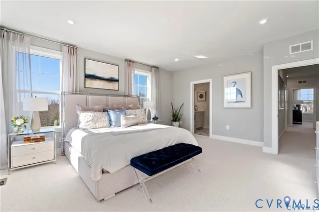 a bedroom with a large bed and paintings on the wall